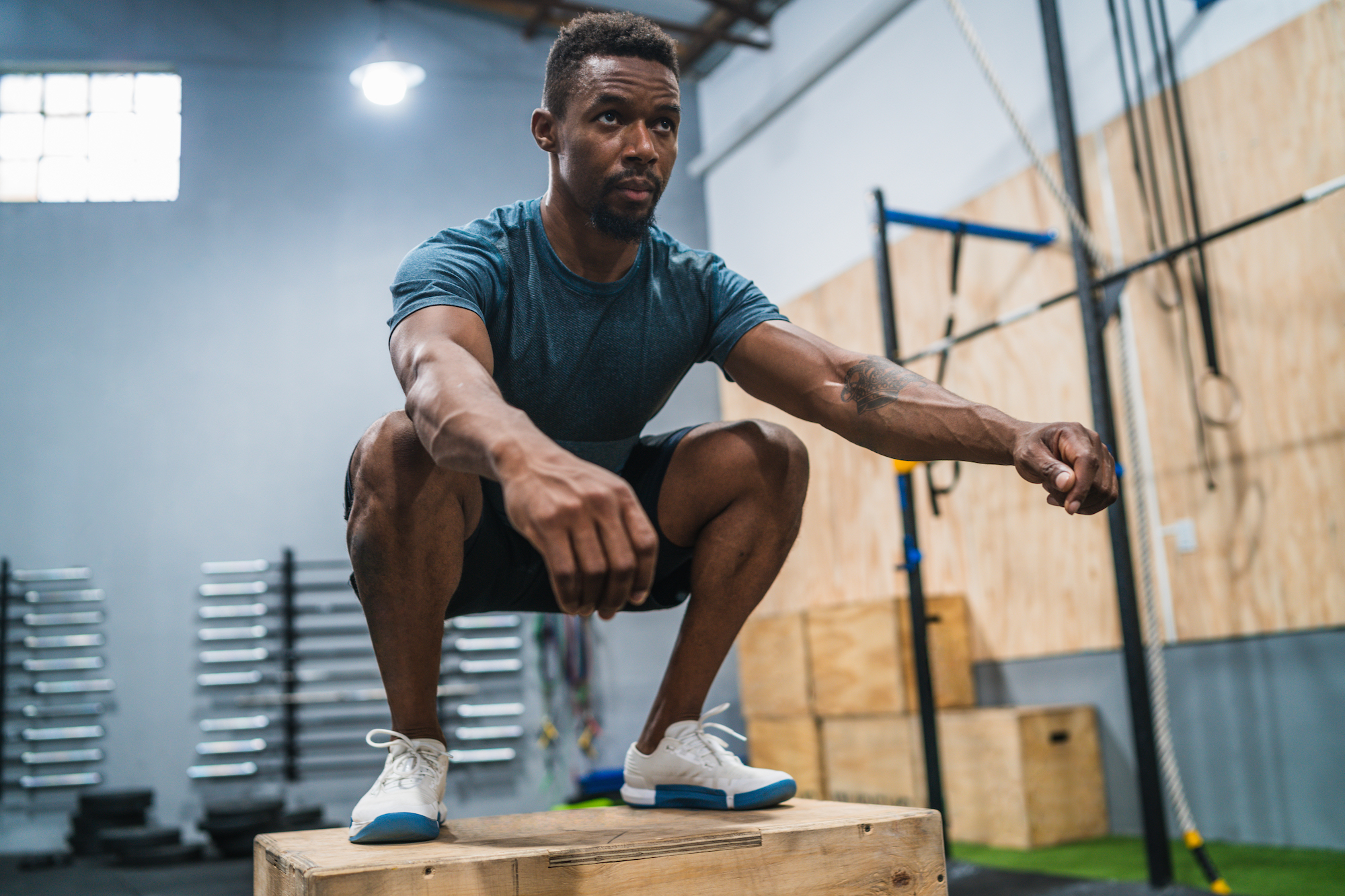Athletic man doing box jump exercise.
